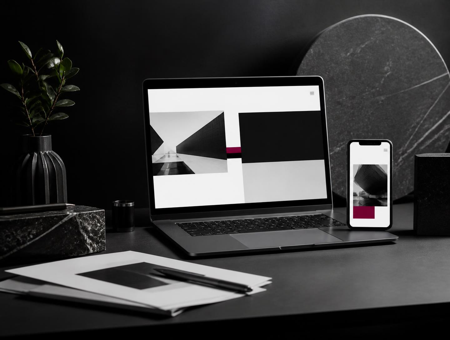 Laptop and mobile phone showing an elegant black, white and magenta website concept