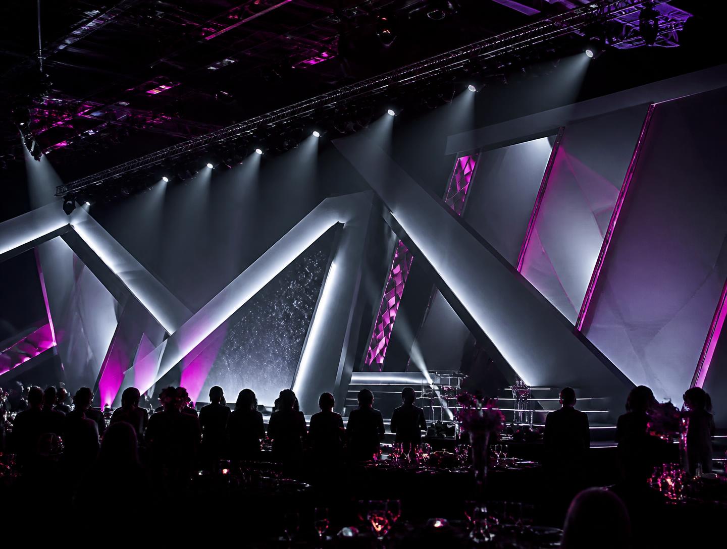 Contemporary corporate event stage with geometric lighting and magenta accents